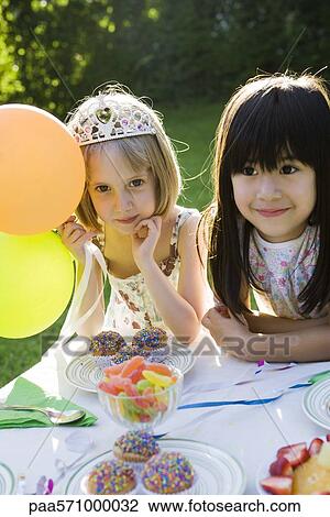 Girls admiring sweets table at outdoor party View Large Photo Image Stock Image - Girls admiring sweets table at outdoor party. Fotosearch