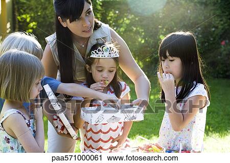 Mother helping daughter open gift at birthday party View Large Photo Image Stock Image - Mother helping daughter open gift at birthday party. Fotosearch