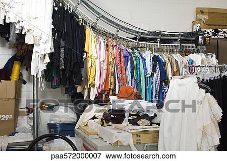 Clothing hanging from hanging garment conveyor View Large Photo Image Stock Photo - Clothing hanging from hanging garment conveyor. Fotosearch