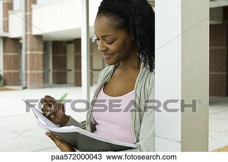 Female college student writing in notebook View Large Photo Image Stock Image - Female college student writing in notebook. Fotosearch