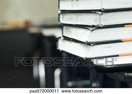 Stock Image - Stack of textbooks on school desk. Fotosearch