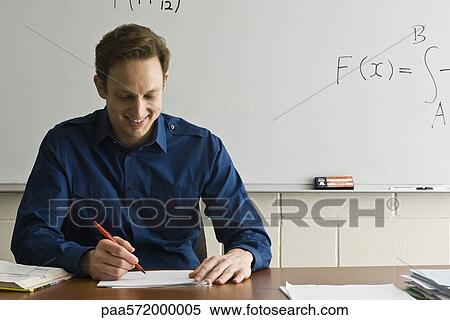 Stock Photography - Teacher marking homework. Fotosearch