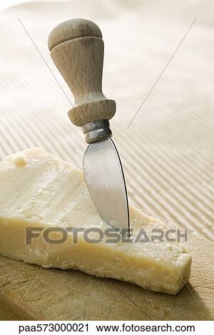 Cheese knife stuck in chunk of Parmaesan cheese View Large Photo Image Stock Image - Cheese knife stuck in chunk of Parmaesan cheese. Fotosearch