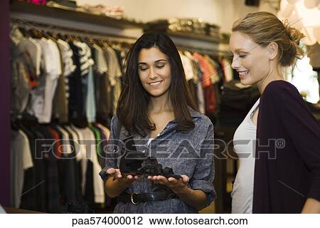 Friends looking at shoes in boutique View Large Photo Image Stock Image - Friends looking at shoes in boutique. Fotosearch