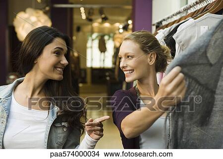 Friends shopping in clothing store View Large Photo Image Picture - Friends shopping in clothing store. Fotosearch