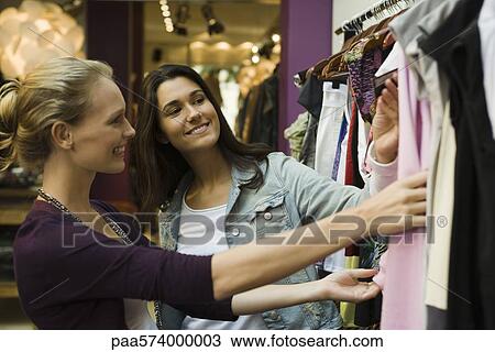 Friends shopping in clothing store View Large Photo Image Stock Image - Friends shopping in clothing store. Fotosearch