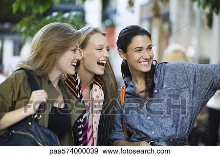 Friends window shopping together View Large Photo Image Stock Photo - Friends window shopping together. Fotosearch