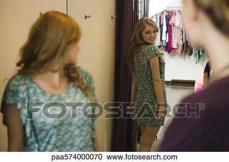 Shopper trying on clothing in fitting room View Large Photo Image Stock Image - Shopper trying on clothing in fitting room. Fotosearch