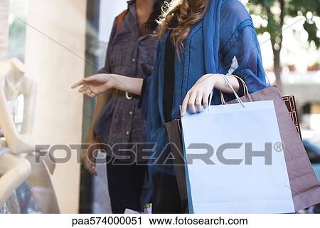 Shoppers looking in shop window, cropped View Large Photo Image Stock Image - Shoppers looking in shop window, cropped. Fotosearch