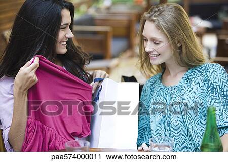 Stock Image - Shoppers showing off new purchases. Fotosearch