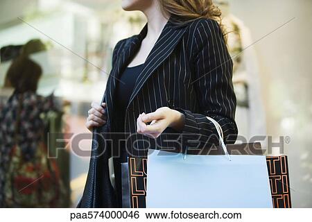Woman carrying shopping bags, cropped View Large Photo Image Stock Photograph - Woman carrying shopping bags, cropped. Fotosearch