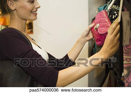 Woman looking at purse in shop View Large Photo Image Stock Photograph - Woman looking at purse in shop. Fotosearch