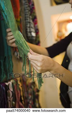 Woman looking at scarf in store, cropped View Large Photo Image Stock Image - Woman looking at scarf in store, cropped. Fotosearch