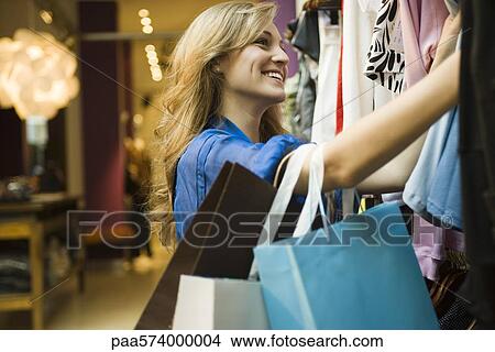 Woman shopping in clothing boutique View Large Photo Image Picture - Woman shopping in clothing boutique. Fotosearch