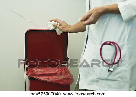 Discarding waste in medical waste bin View Large Photo Image Stock Image - Discarding waste in medical waste bin. Fotosearch