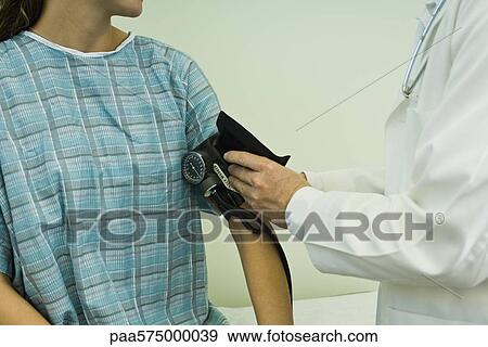 Stock Photo - Doctor checking patient's blood pressure. Fotosearch