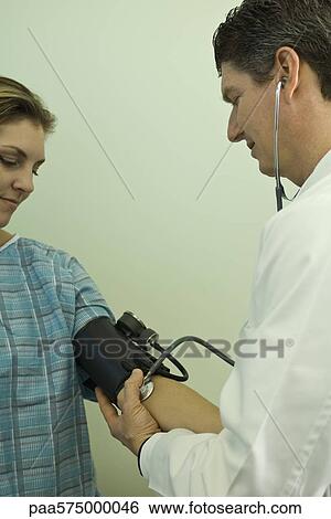 Doctor checking patient's blood pressure View Large Photo Image Stock Photograph - Doctor checking patient's blood pressure. Fotosearch