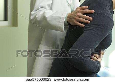 Doctor comforting a patient experiencing severe abdominal pain View Large Photo Image Stock Image - Doctor comforting a patient experiencing severe abdominal pain. Fotosearch