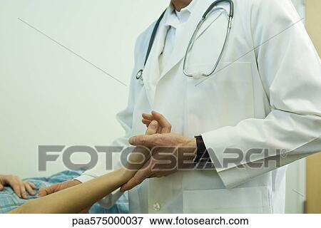 Stock Photo - Doctor examining patient's arm. Fotosearch