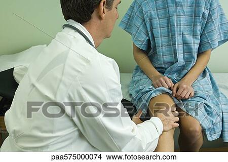 Doctor examining patient's leg and knee View Large Photo Image Picture - Doctor examining patient's leg and knee. Fotosearch