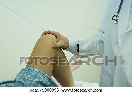 Doctor examining patient's leg and knee View Large Photo Image Stock Photograph - Doctor examining patient's leg and knee. Fotosearch
