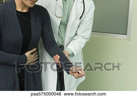 Doctor holding patient's arm and helping her walk View Large Photo Image Stock Photo - Doctor holding patient's arm and helping her walk. Fotosearch
