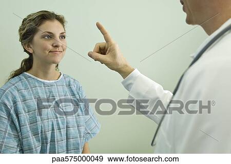 Doctor testing patient's ocular responsiveness View Large Photo Image Stock Photo - Doctor testing patient's ocular responsiveness. Fotosearch