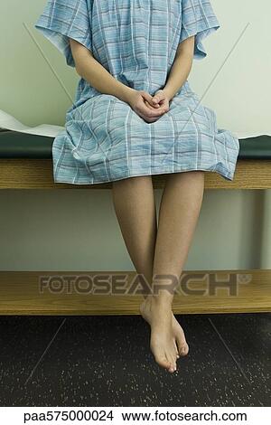 Female patient sitting on examination table View Large Photo Image Picture - Female patient sitting on examination table. Fotosearch