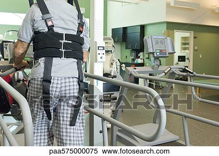 Man exercising on treadmill with assistance of rehabilitation harness supporting body weight View Large Photo Image Stock Photography - Man exercising on treadmill with assistance of rehabilitation harness supporting body weight. Fotosearch