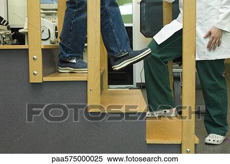Patient practicing going down steps as part of rehabilitation exercise View Large Photo Image Stock Photography - Patient practicing going down steps as part of rehabilitation exercise. Fotosearch