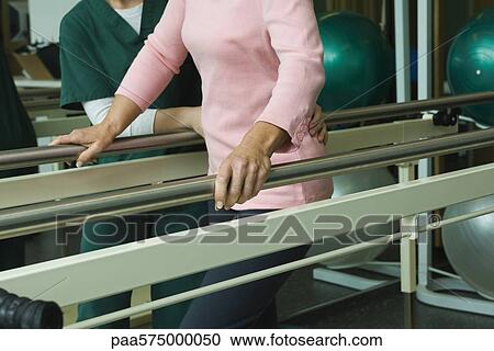 Patient undergoing post-surgery rehabilitation exercises to regain ability to walk View Large Photo Image Stock Image - Patient undergoing post-surgery rehabilitation exercises to regain ability to walk. Fotosearch