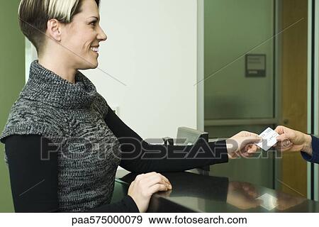 Stock Photo - Woman showing medical insurance card. Fotosearch
