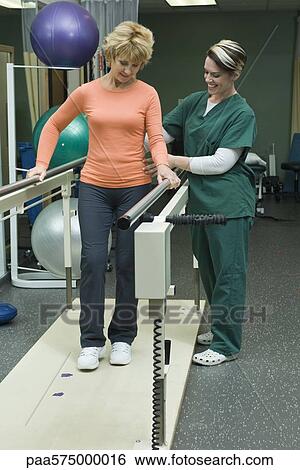 Woman undergoing post-surgery rehabilitation exercises to regain ability to walk View Large Photo Image Stock Photograph - Woman undergoing post-surgery rehabilitation exercises to regain ability to walk. Fotosearch