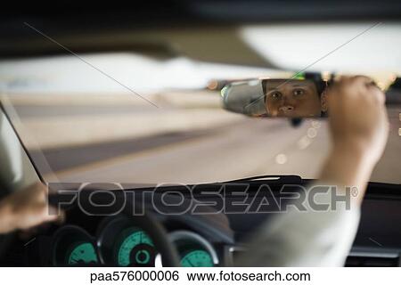 Driver driving adjusting rearview mirror View Large Photo Image Stock Photograph - Driver driving adjusting rearview mirror. Fotosearch