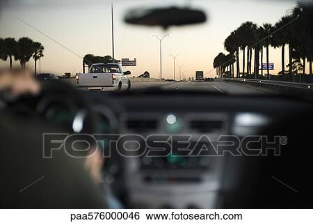 Stock Photograph - Driving along freeway in light traffic at dusk. Fotosearch