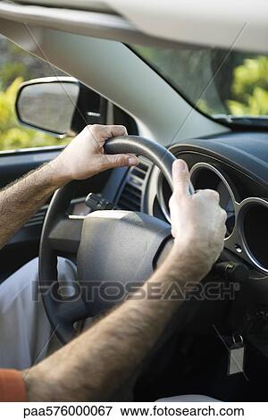 Driving car with both hands on the steering wheel View Large Photo Image Stock Photo - Driving car with both hands on the steering wheel. Fotosearch