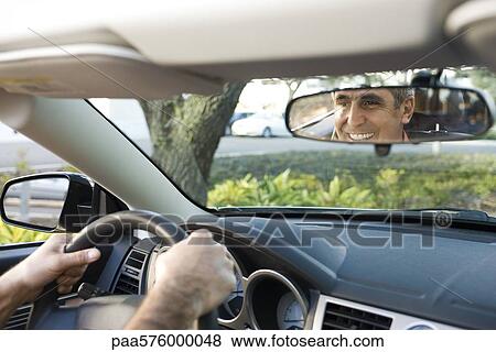 Man driving, reflection in rearview mirror View Large Photo Image Stock Photo - Man driving, reflection in rearview mirror. Fotosearch