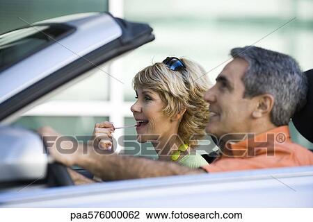 Mature couple in car together, woman putting on lip gloss View Large Photo Image Stock Image - Mature couple in car together, woman putting on lip gloss. Fotosearch
