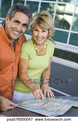 Mature couple looking at map together planning road trip View Large Photo Image Stock Photo - Mature couple looking at map together planning road trip. Fotosearch