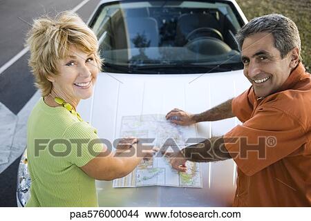 Mature couple on road trip checking map View Large Photo Image Picture - Mature couple on road trip checking map. Fotosearch