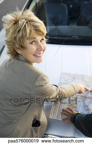 Woman checking road map, smiling at camera View Large Photo Image Stock Photo - Woman checking road map, smiling at camera. Fotosearch