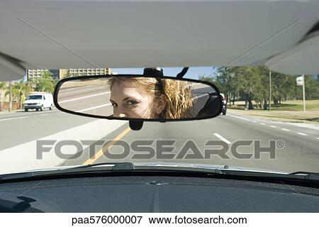 Woman driving, checking rear view mirror View Large Photo Image Stock Photo - Woman driving, checking rear view mirror. Fotosearch