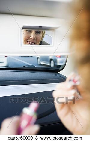 Woman in car putting on makeup using visor vanity mirror View Large Photo Image Stock Photo - Woman in car putting on makeup using visor vanity mirror. Fotosearch