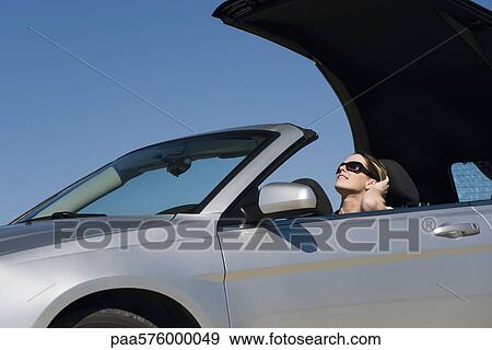 Woman putting convertible top down preparing for drive on summer day View Large Photo Image Stock Photo - Woman putting convertible top down preparing for drive on summer day. Fotosearch