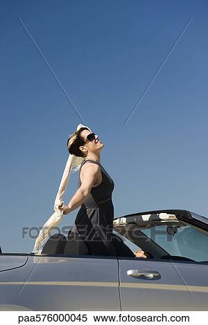 Woman standing up in convertible with arms outstretched enjoying the outdoors View Large Photo Image Stock Photography - Woman standing up in convertible with arms outstretched enjoying the outdoors. Fotosearch