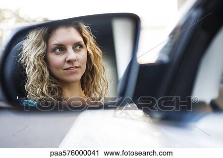 Young woman driving car, reflection in side-view mirror View Large Photo Image Stock Image - Young woman driving car, reflection in side-view mirror. Fotosearch
