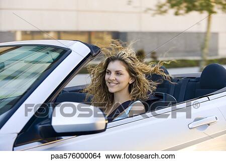Picture - Young woman driving convertible. Fotosearch