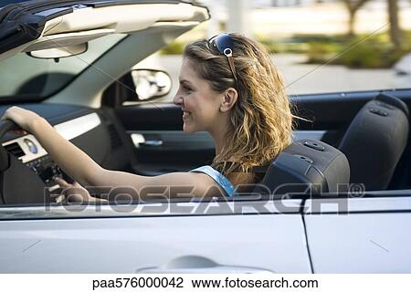 Young woman driving convertible View Large Photo Image Stock Image - Young woman driving convertible. Fotosearch