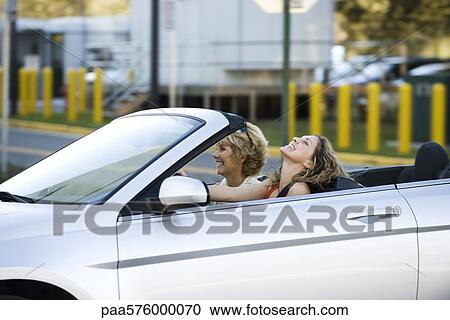 Young woman driving convertible, enjoying outing with mother View Large Photo Image Stock Image - Young woman driving convertible, enjoying outing with mother. Fotosearch