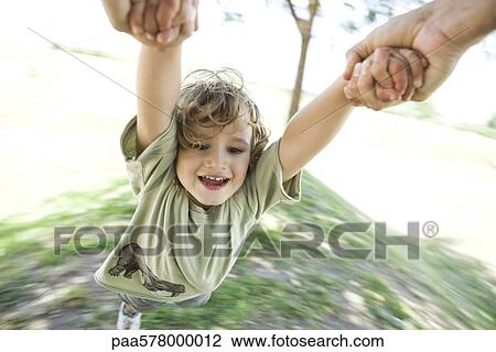 Boy being swung through air by his arms View Large Photo Image Stock Image - Boy being swung through air by his arms. Fotosearch